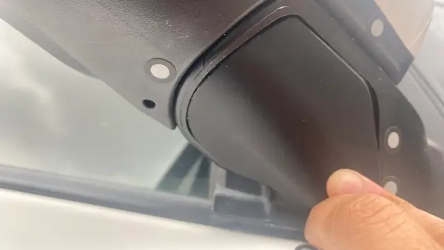 Black printed trim cover fitted under the side mirror of a white Toyota Sienna