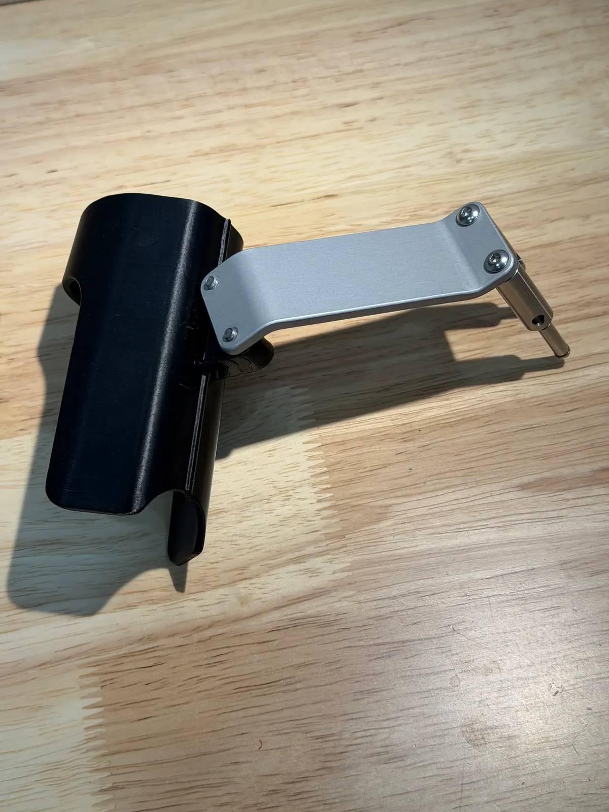 Black holder attached to a silver aluminum mounting arm, seen from above